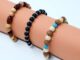 three neutral colored beaded bracelets on a peach roll of paper
